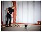 Frau streicht Wand mit LIVARNO® Arbeitsleuchte „The Painter“.