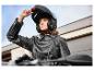 Frau auf einem Motorrad mit einem ULTIMATE SPEED® Klapphelm und einer Lederjacke.