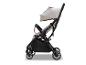 Leichter und kompakter beiger Kinderwagen mit schwarzem Gestell, von der Seite gesehen.