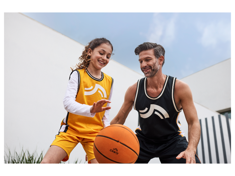 Vater und Tochter spielen Basketball mit einem Crivit Ball.