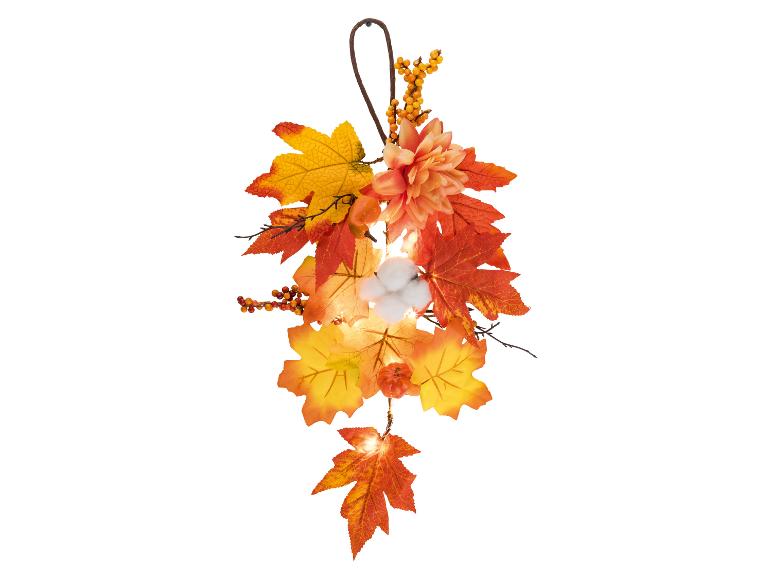 Herbstliche Girlande mit Blättern, Beeren, Blumen, Baumwolldetails und Beleuchtung.