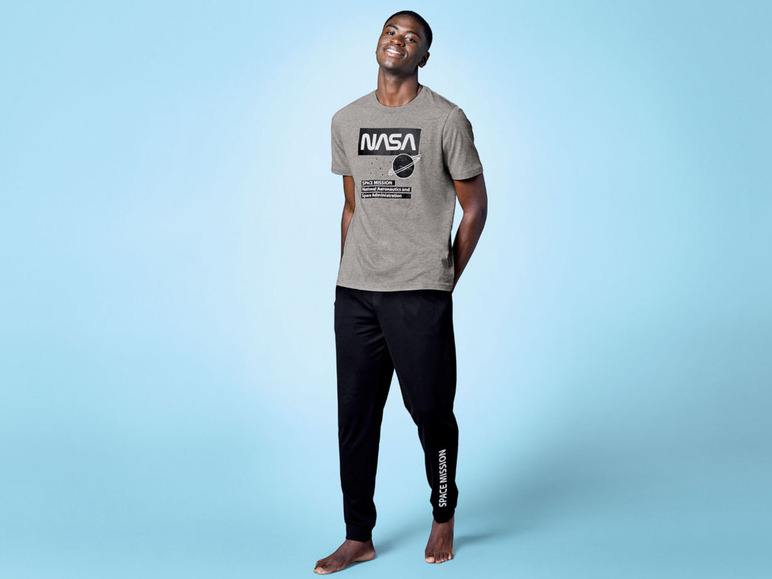 Mann trägt ein graues NASA T-Shirt mit schwarzen Hosen.