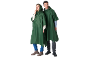 Zwei Personen in dunkelgrünen Kapuzen-Regenponchos, Jeans und Stiefeln.