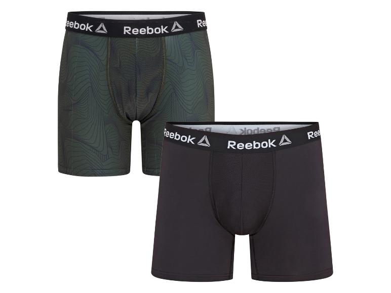Zwei Reebok Boxershorts, eine grüne gemusterte und eine schwarze.