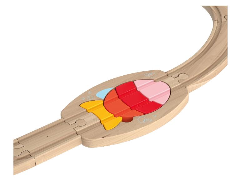 Eine Holzeisenbahnschiene mit einem bunten Fisch-Puzzle-Einsatz.