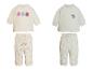 Zwei Baby-Outfits, eines mit Blumenmuster und eines mit Eisbärenmuster.