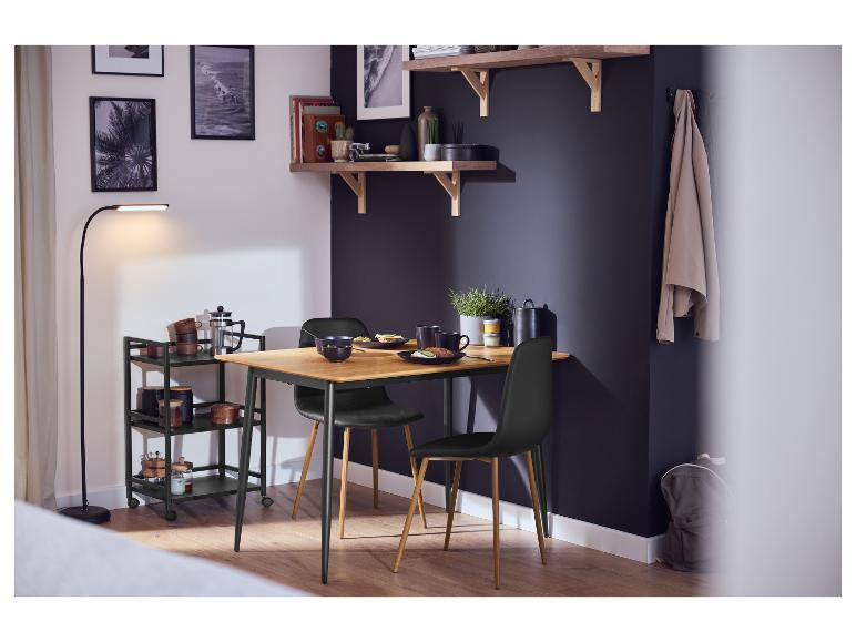 Zwei schwarze LIVARNO® Esszimmerstühle mit Holzbeinen um einen Tisch.