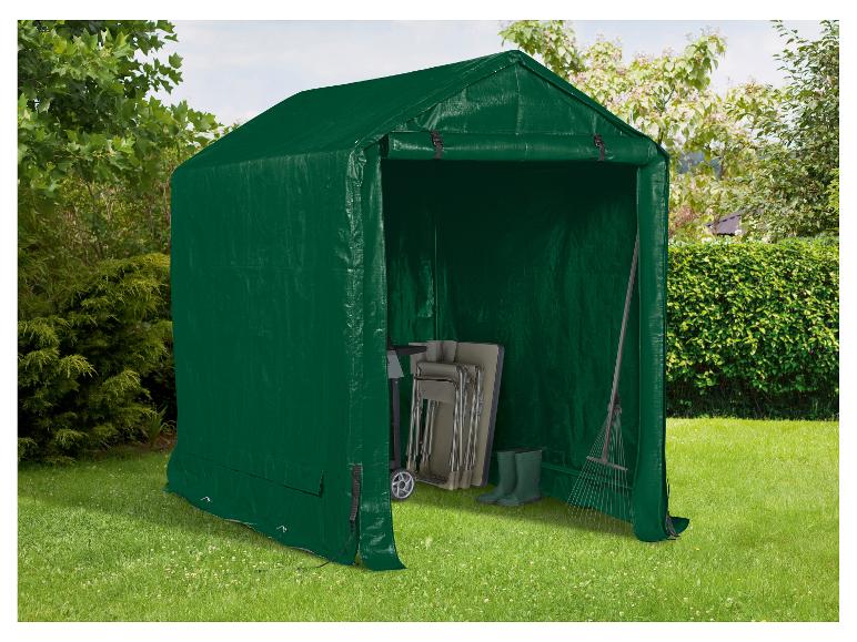 Grüner Gartenschuppen mit Gartengeräten und Klappstühlen auf einer Wiese.