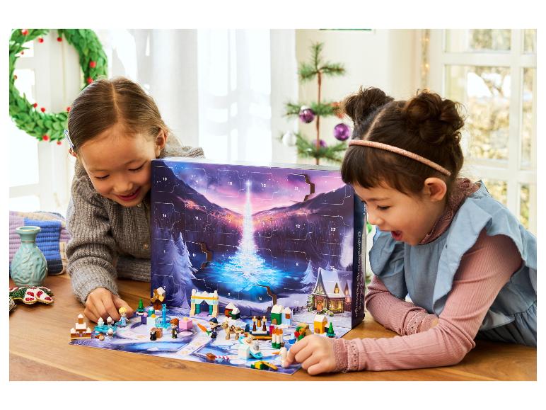 Zwei Mädchen spielen mit einem LEGO Disney Frozen Adventskalender, mit Figuren und Zubehör.