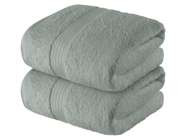 Zwei gefaltete Badetücher, hellgrau-grün.