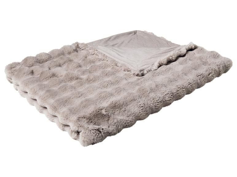 Weiche, flauschige beige Decke, zur Hälfte gefaltet, mit sichtbarer Textur.