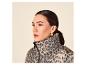 Frau in einer Leoparden-Pufferjacke mit goldenen Ohrringen.