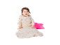 Lächelndes Baby in einem Schlafsack mit Hasen- und Mondmotiven, mit einem rosa Kissen.