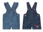 Zwei Baby-Jeans-Overalls: einer mit Herz, einer mit Krabbe.