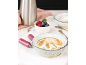Dessertschalen mit gebrannter Zuckerhaube, Beeren und Sahnekapseln auf einer Marmoroberfläche.