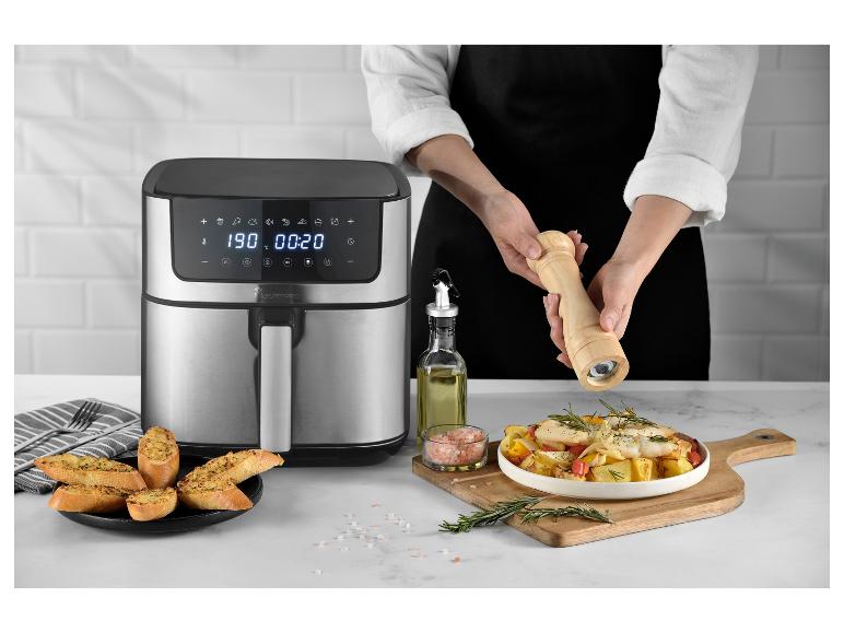 MasterPRO Heißluftfritteuse mit zubereitetem Essen und einer Person, die würzt.