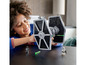Ein Kind baut einen LEGO Star Wars TIE Fighter.