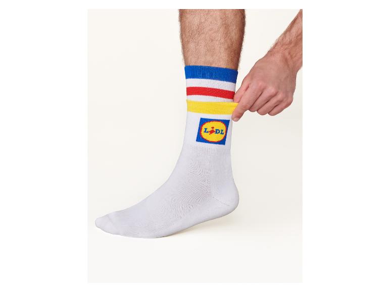 Weiße Socken mit blauen, roten und gelben Streifen, mit einem Supermarkt-Logo.