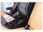 Frau stellt Kindersitz auf beigem Ledersitz im Auto ein.