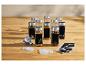Gewürzgläser-Set aus Glas mit Metalldeckeln, Trichter und schwarzen Etiketten auf einem Holztisch.