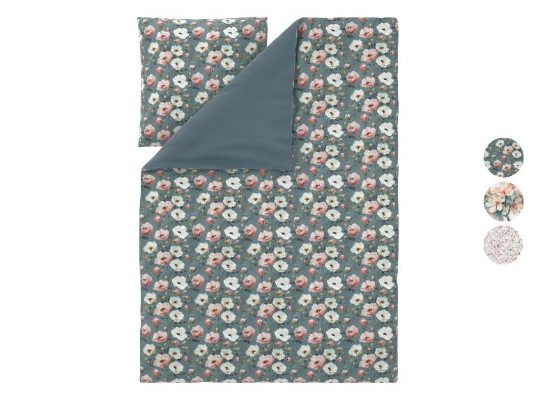 Bettwäsche-Set mit rosa und weißem Blumenmuster auf blaugrünem Hintergrund.