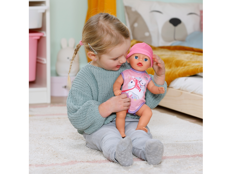Kleines Mädchen spielt mit einer Puppe im Kinderzimmer.