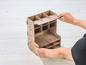 Eine Person baut eine Holzbox mit mehreren Fächern zusammen.