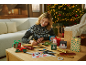Frau bastelt Weihnachtsgeschenkboxen und -tüten mit festlichen Designs.