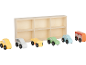 Spielzeugautos und ein Bus aus Holz vor einem Holzregal mit sechs Fächern.