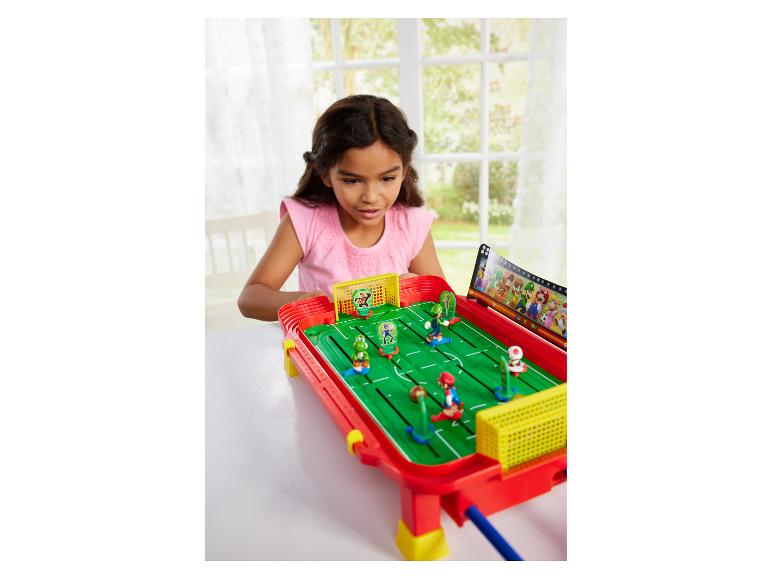 Mädchen spielt Epoch Games Super Mario Football Striker, ein Tischfußballspiel.