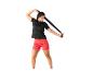 Frau in schwarzem T-Shirt und roten Shorts dehnt sich mit einem schwarzen Band.