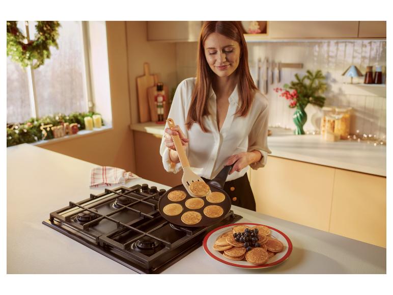 Eine Frau backt Mini-Pfannkuchen in einer SILVERCREST® Pancake-Pfanne.