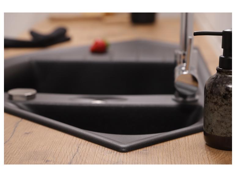 Schwarzes Eckspülbecken mit Holzplatte und Seifenspender.