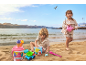 Zwei Kinder spielen mit Sandspielzeug, darunter ein Eiskübel und eine Gießkanne, am Strand.