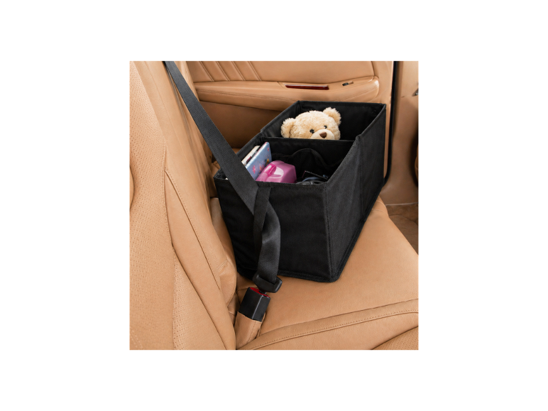 Schwarzer Auto-Organizer mit Teddybär und anderen Gegenständen, mit Sicherheitsgurt in beigem Autointerieur befestigt.