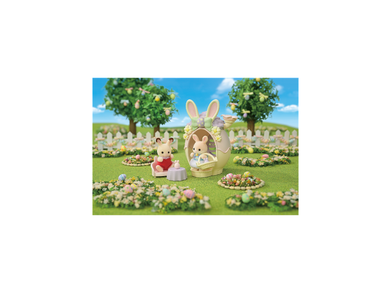 Osterhasen-Spielzeug in einem Garten mit dekorativen Eiern und Bäumen.