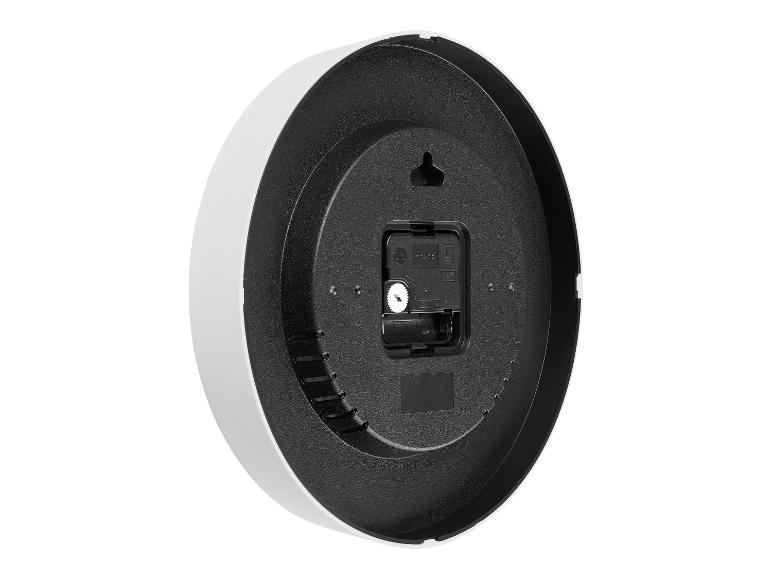 Rückseite einer schwarz-weißen Wanduhr mit Quarzwerk und Batteriefach.