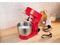 Rote Küchenmaschine mit Schneebesen in einer Schüssel mit Schlagsahne, auf einer Küchenzeile.