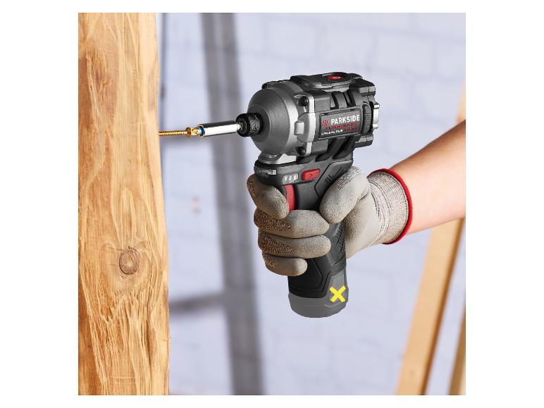 Hand im Arbeitshandschuh verwendet Schlagschrauber zum Eindrehen in einen Holzbalken.
