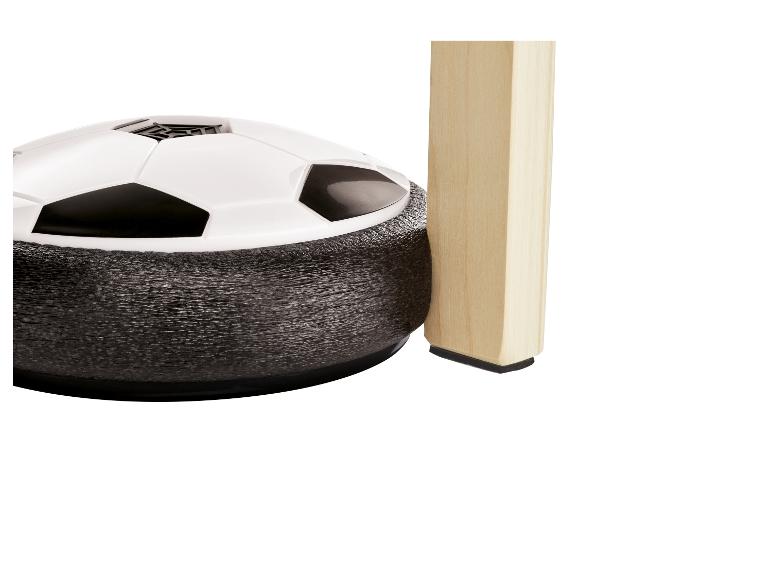 Schwebender Fußball neben einem hölzernen Tischbein