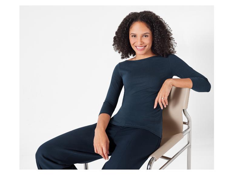 Eine Frau in einem dunkelblauen Shirt und Hose.