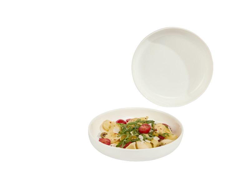 Nudelgericht mit Kirschtomaten, Rucola und Oliven, mit einem leeren Teller darüber.