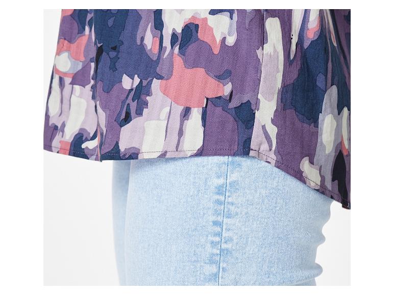 Eine hellblaue Jeans mit einer rosafarbenen, violetten und blauen Bluse mit einem abstrakten Blumenmuster.