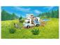 LEGO Friends Wohnmobil mit Figuren und Zubehör in grüner Landschaft.