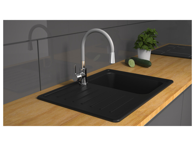 Ein schwarzes Küchenspülbecken mit Wasserhahn und Arbeitsplatte.
