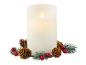 Eine weiße LED-Kerze mit Flammeneffekt, umgeben von Tannenzweigen, Zapfen und roten Beeren.