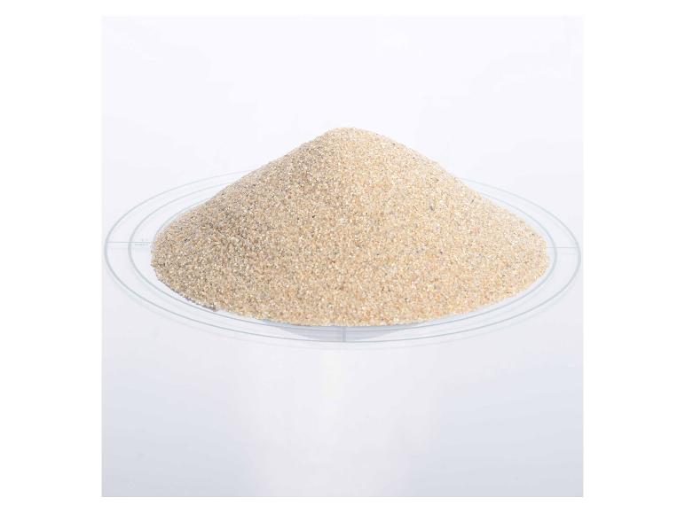 Ein Haufen feiner Sand auf einer transparenten Platte mit Messmarkierungen.