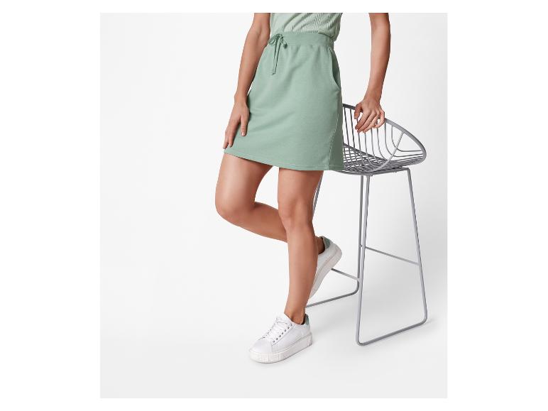 Ein hellgrüner Minirock und weiße Sneaker.