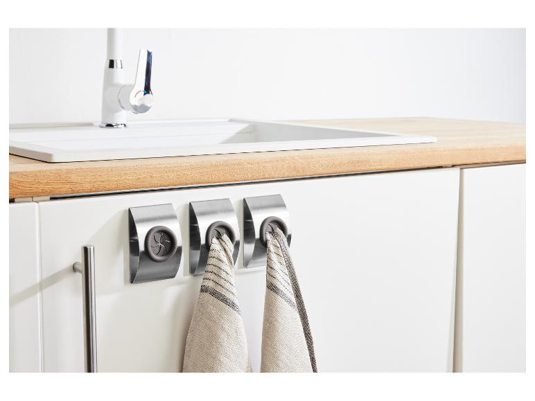 Küche mit Spüle, Wasserhahn und drei Handtuchhaltern aus Edelstahl mit Geschirrtüchern.