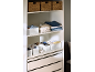 Kleiderschrank mit Aufbewahrungskörben, gefalteter Kleidung und Schubladen.